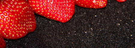 5 strawberries on a black background. Berries on a shiny black table.の写真素材