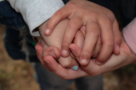 Crossed children's hands. Lots of fingers. Symbol of friendship. One for all and all for one.