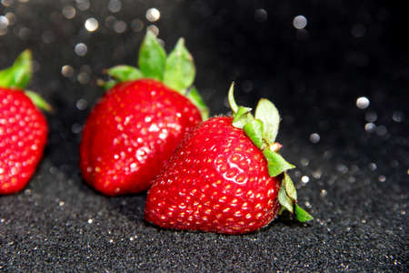 Strawberry on a black background. Brilliant background with berries.の写真素材