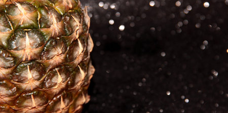 Part of a pineapple on a black shiny backgroundの写真素材