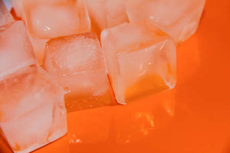 Chunks of ice on an orange background. Ice on a bright background.の写真素材