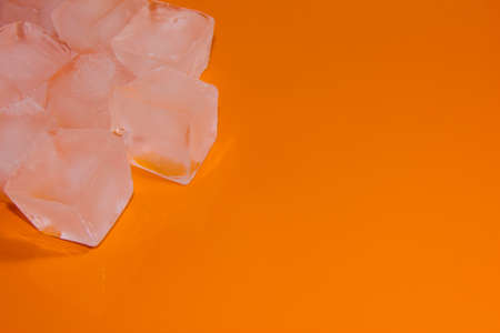 Chunks of ice on an orange background. Ice on a bright background.の写真素材