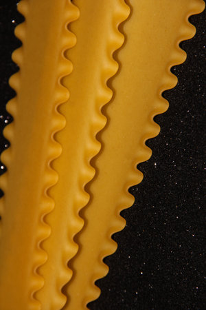 Pasta on a black shiny background. Lasagna sheets on a dark background. Food frame.