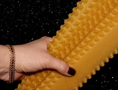 Lasagna sheets in a woman's hand. A girl holds pasta on a black background.の写真素材