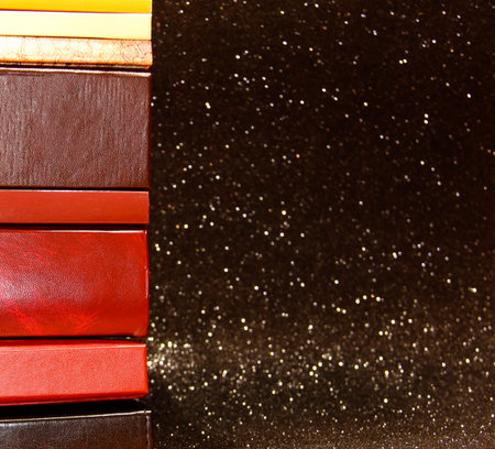 A stack of books on a black background. Many colorful books. Books in a long row.の写真素材