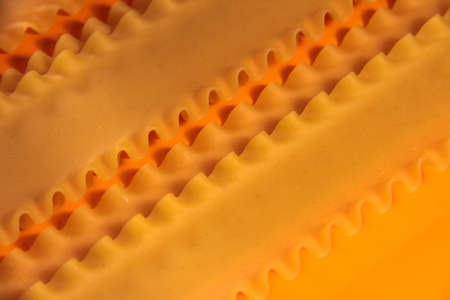 Macaroni on an orange background. The frame is bright. Flour products. The lasagna sheets.の写真素材
