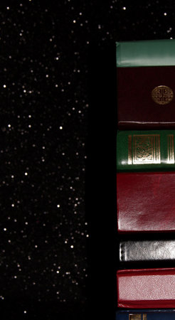 A stack of books on a black background. Many colorful books. Books in a long row.の写真素材