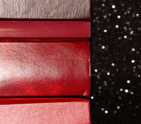 A stack of books on a black background. Many colorful books. Books in a long row.の写真素材