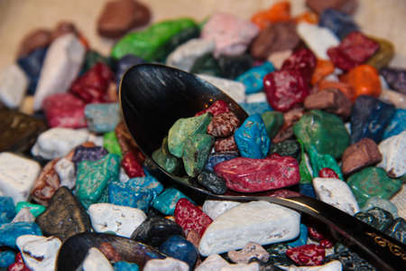 Colorful candies on a spoon. Chocolate in the form of stones.の写真素材