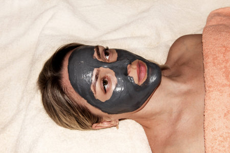 Girl with a cleansing mask for the face. Spa procedures. Mask based on activated carbon.の写真素材