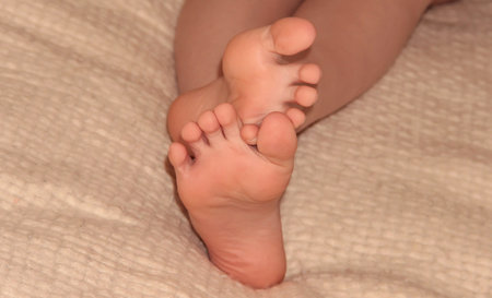 Children's feet on a blanket. Feet on the bed.