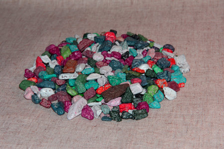 Multi-colored sweets on the fabric. Chocolate candies in the form of stones.