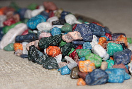 Multi-colored sweets on the fabric. Chocolate candies in the form of stones.