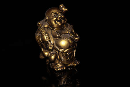 Laughing Buddha Hotei on a black backgroundの写真素材