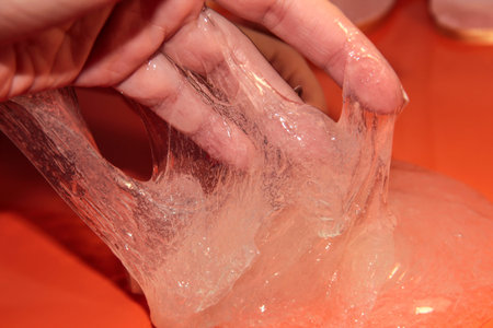Slime in hand on orange background