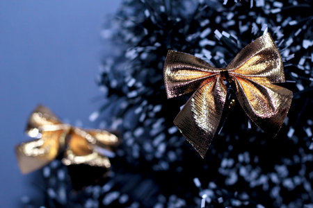 gold bow on the branch of a fluffy Christmas tree