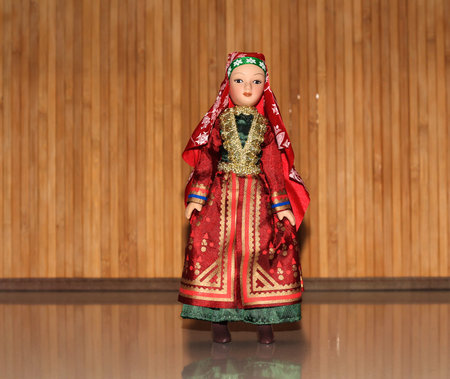 Doll in national dress on a wooden background.