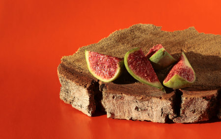 Fig slices on a wooden background. Figs on a bright orange background.