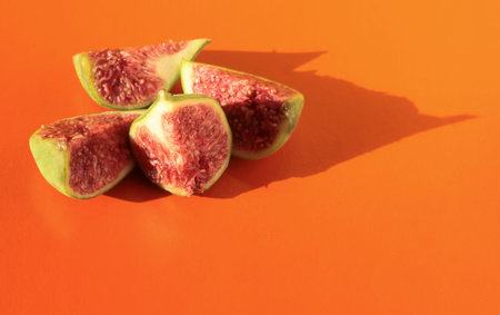 Fig slices on an orange background. Figs on a bright background.