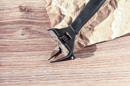 Spanner on a wooden background. Oldest tool.の写真素材