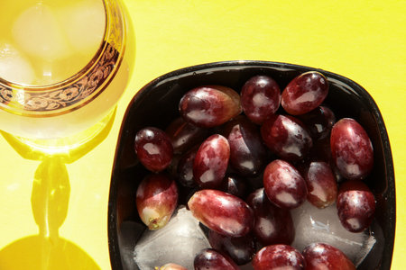 Grapes in a crystal bowl with an icy drink on a bright background.の写真素材