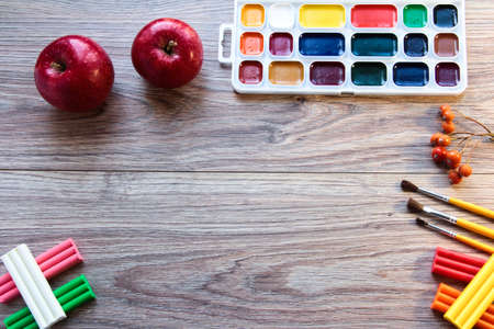 On the wooden table are paints, brushes and plasticine.の写真素材