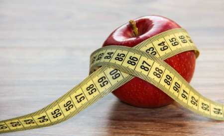 A red Apple is measured by a meter. Slimness and diet.