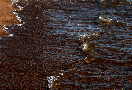 Sea background. Waves on the background of pebbles. Seashore.