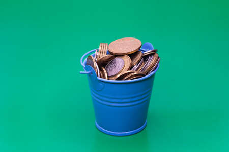 Bucket of coins. Blue bucket with Ukrainian money. Written in Ukrainian: 1 hryvnia.の写真素材