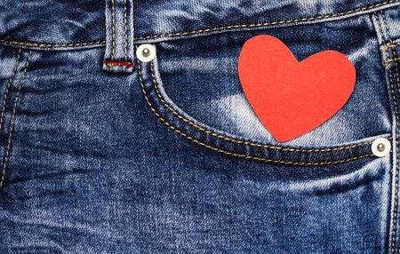Red heart in jeans pocket. Love symbol. Valentine's card.