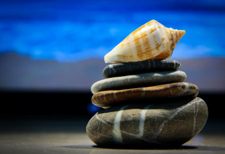 Shell and pyramid of sea stones on the background of the sea. Relaxation.の写真素材