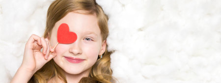 Girl on the clouds with red hearts. Portrait of a child.