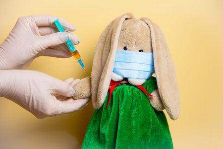 A bunny in a mask is given an injection. Vaccination.