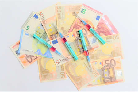 Syringes and masks on banknotes. Expensive treatment.の写真素材