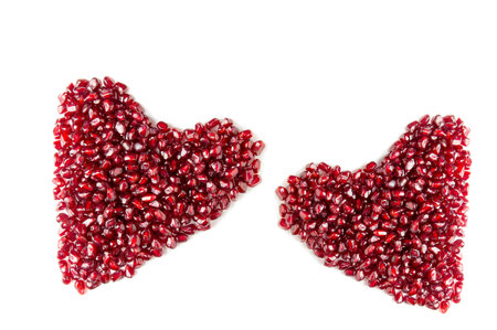 Heart from pomegranate seeds on a white background.の写真素材