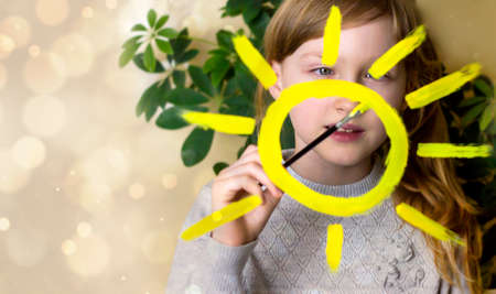 The child draws the sun on the window. A game. Drawing.の写真素材