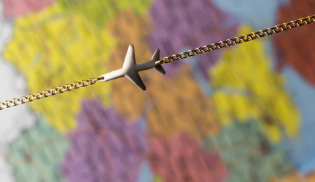 Gold plane on a chain on the background of the map.の写真素材