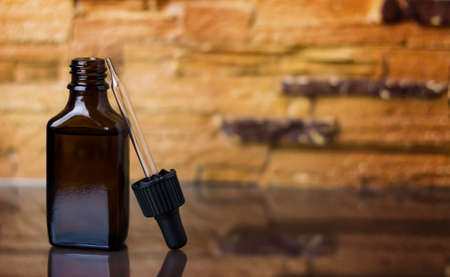 Bottle with a pipette on a beige background. Brown container with cosmetic serum.の写真素材