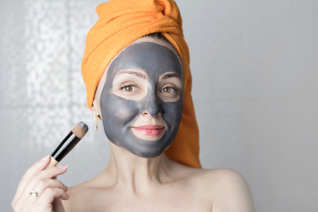 Girl with a cosmetic mask on her face. Purifying black mask for the skin.の写真素材