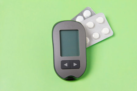 A device that measures blood sugar. Blood glucose meter with pills.