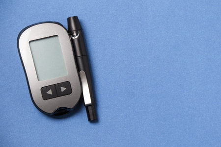 Glucometer with a needle on a blue background. Measurement of blood glucose.の写真素材