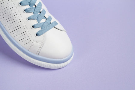White sneakers on a purple background. Footwear.