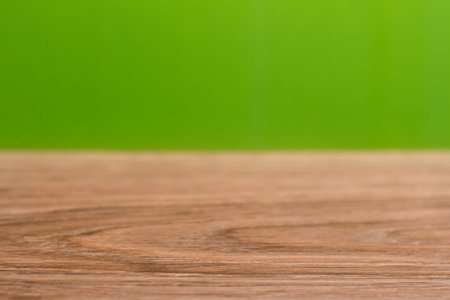 Background with wooden table and green bokeh.
