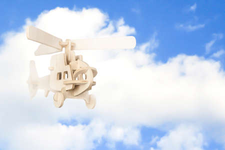 Wooden helicopter flies in the sky. Toy transport.の写真素材