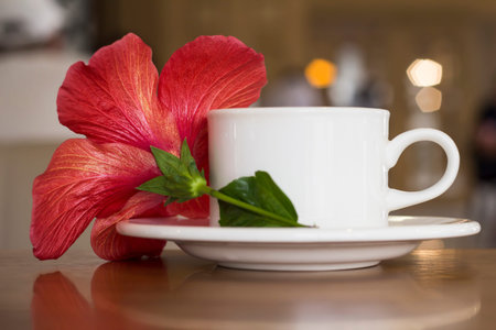 A cup of tea with a red flower on the table.の写真素材
