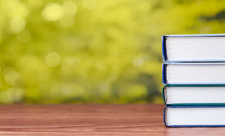 A stack of books on a wooden table with place for text.の写真素材