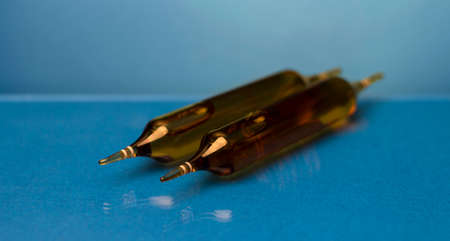 Ampoules with medicine on a blue background.の写真素材