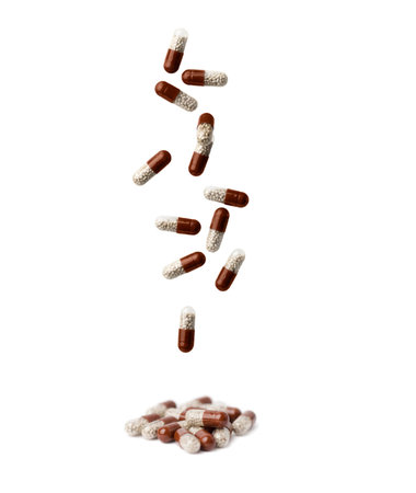 Falling brown medication capsules isolated on white background.