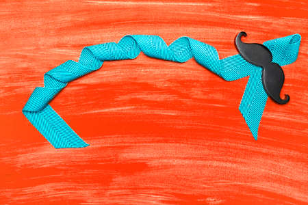 Blue ribbon with a man's mustache on a watercolor background.の写真素材
