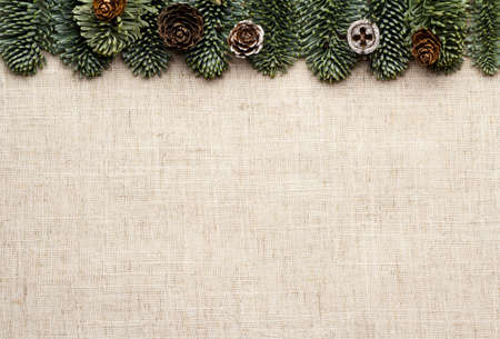 New Year's greeting. Linen background with fir branches and cones.の写真素材